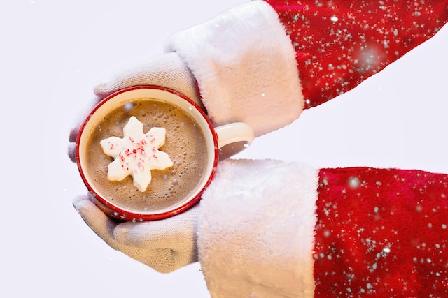 Santa holding hot chocolate with a snowflake marshmallow.